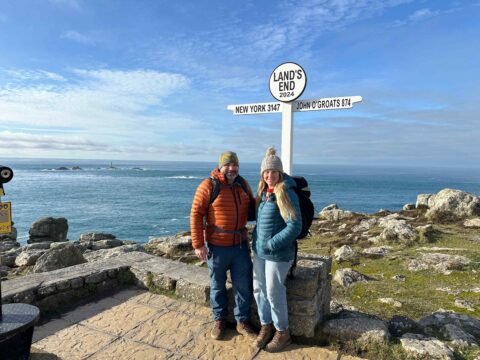 Couple in front of Land's End Signpost